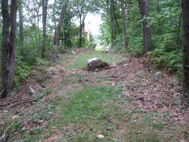 DCR sewer easement with encroachments (lawn clippings, chair, archery items).