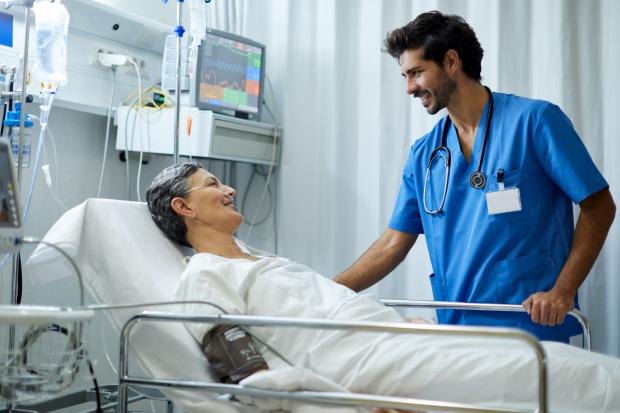 Patient in a hospital bed talking to a doctor