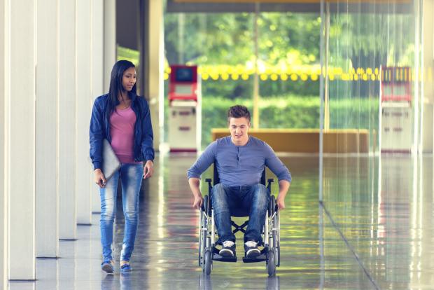 Woman walking next to a man in a wheelchair