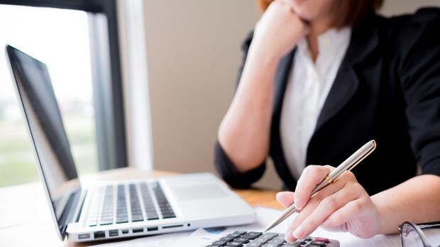 Businesswoman using a laptop and calculator