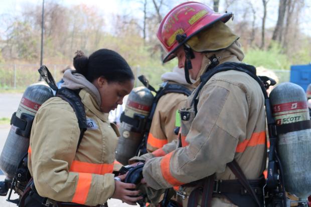 Firefighter assisting a girl with SCBA mask