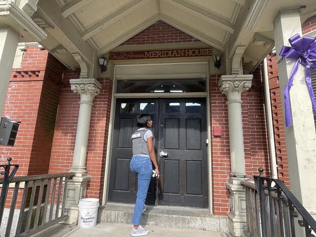 Ellen Winfrey stands at the front doors of the Meridian House in East Boston. 