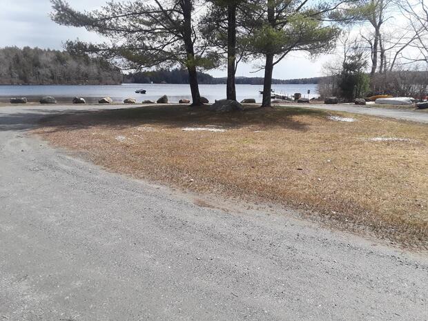 gravel circular road that abuts water with large boulders to prevent trailer launching