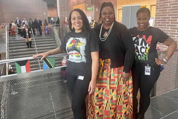 A group of three women dressed in attire celebrating their cultures
