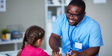 A pediatrician meets with a child.