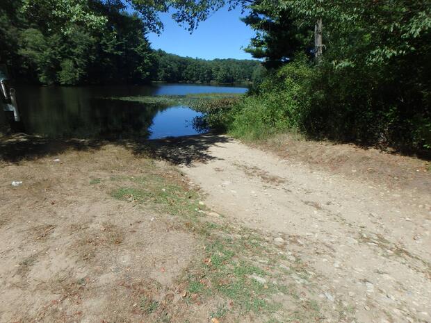 gravel ramp leading to waters edge with surrounding trees