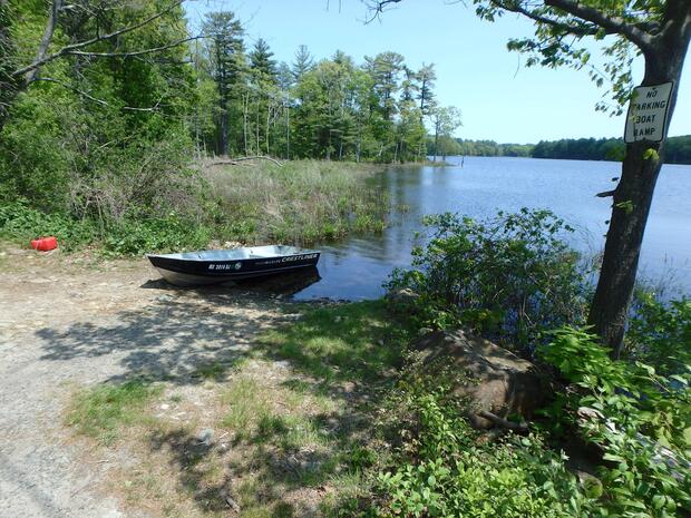 a gravel launch near the road leading into the pond