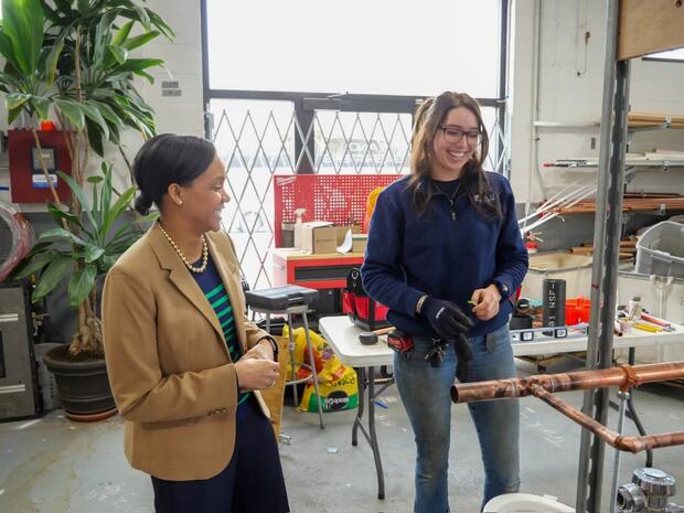 Secretary Jones (left) meets female plumbing apprentice (right)