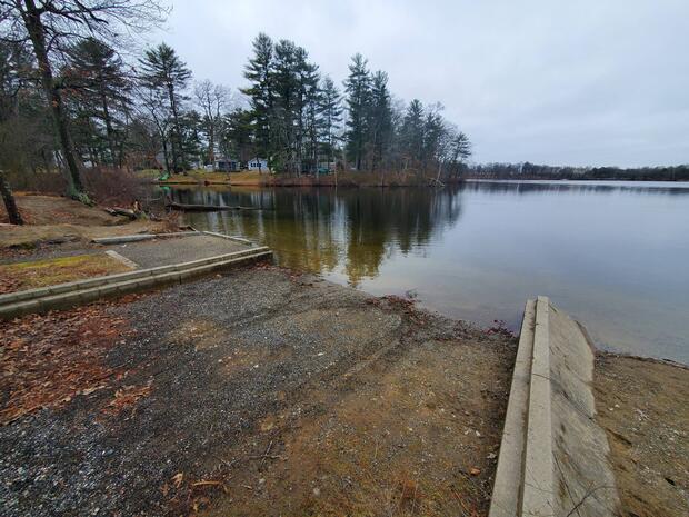 large gravel boat ramp terminating into dug pond with concrete wing walls
