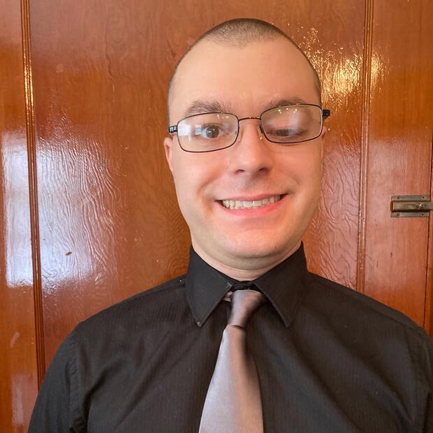 a white man wearing glasses and a black shirt