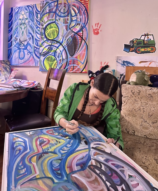A photo of Serina Gordon signing her artwork.