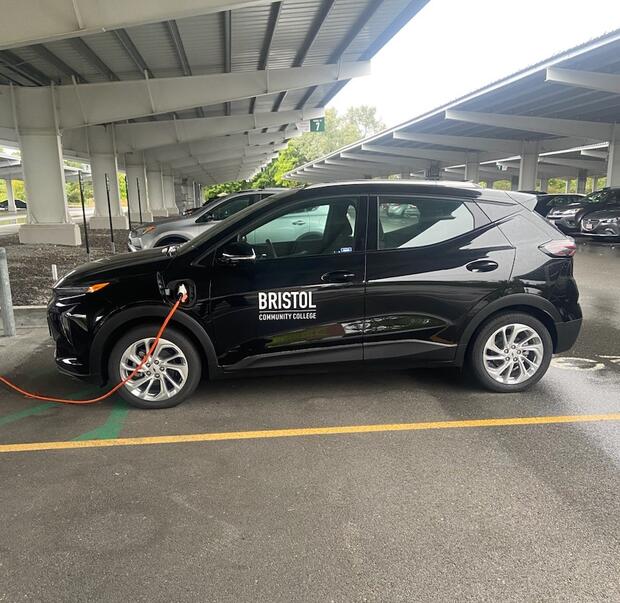 Electric vehicle charging at an outdoor charging station. 