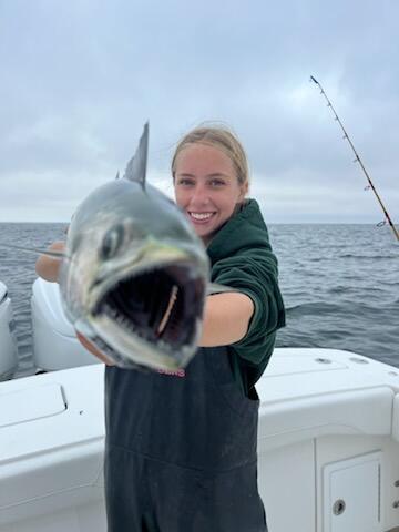 A young angler holding her fish up to the camera.
