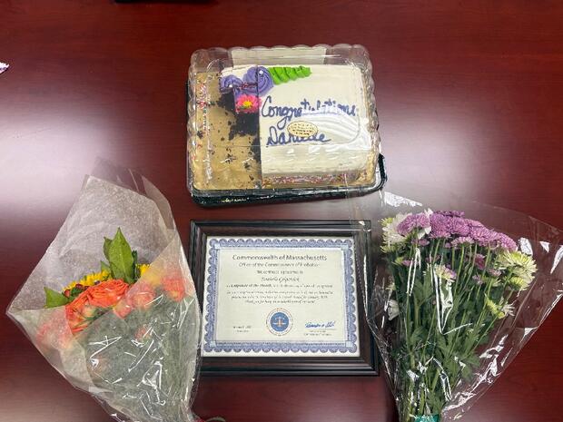 Cake, flowers, and a certificate on a table
