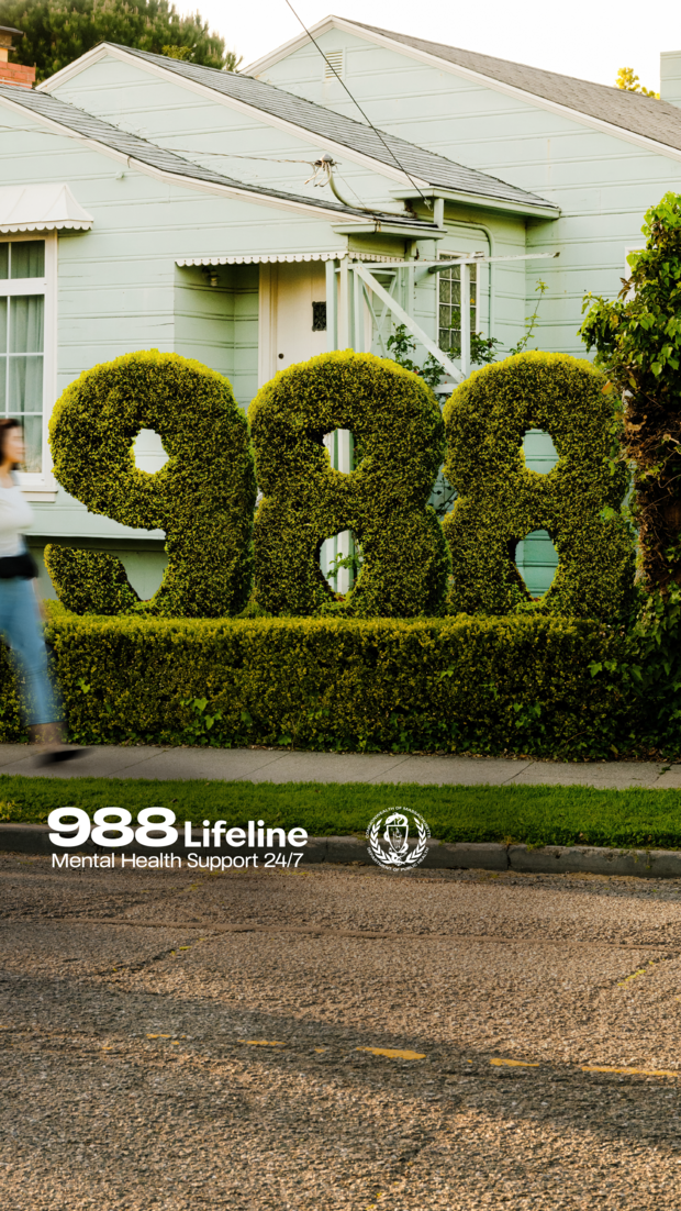 Hedges shaped in the numbers 988 with person walking by on the sidewalk. Text: 988 Lifeline, mental health support 24/7.