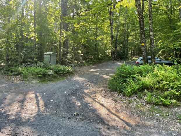 Small gravel parking area surrounded by trees