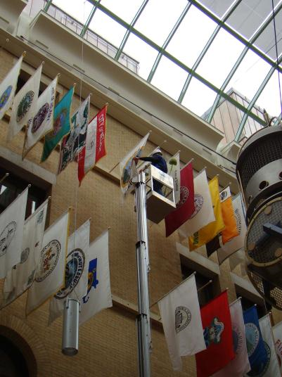 A worker on a boom lift is handling a town flag in Great Hall
