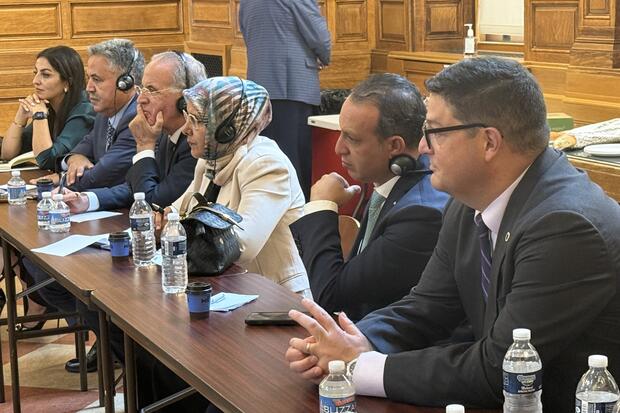 A group of six people sit, listening intently 