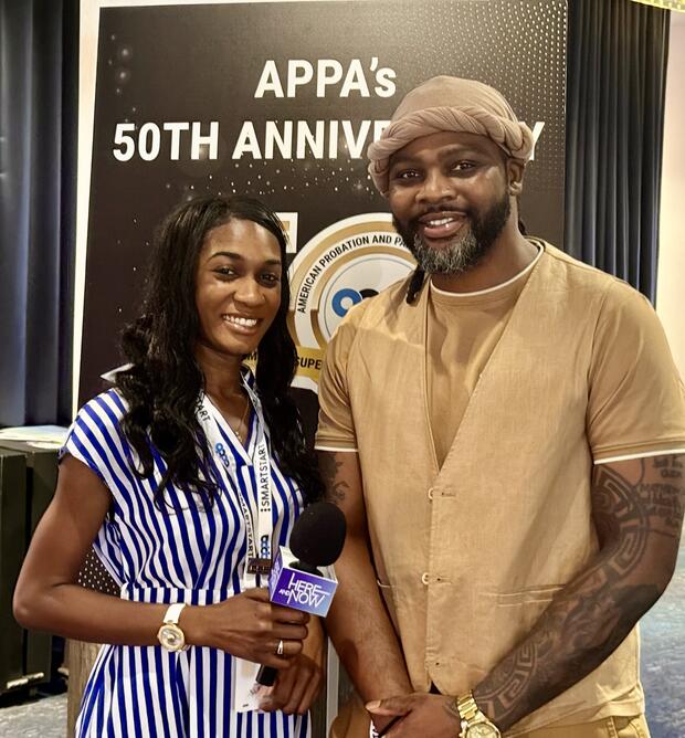 Two people stand in front of a sign that reads 'APPA's 50th Anniversary