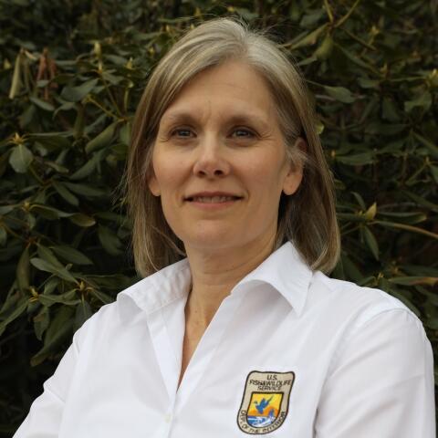 Kyla Hastie wearing white shirt with Fish and Wildlife logo