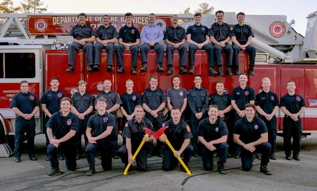 firefighters on and around a ladder truck