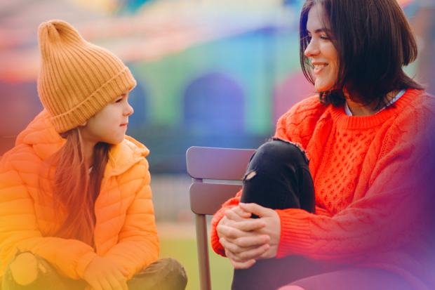 a mother and child talking on a bench