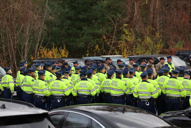 Massachusetts State Police officers assembled in formation for a pre-event roll call before a large public safety operation.