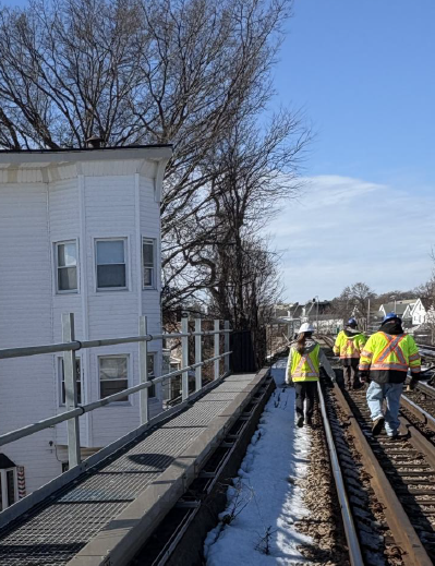DPU and MBTA personnel in safety gear inspect tracks on the Red Line.