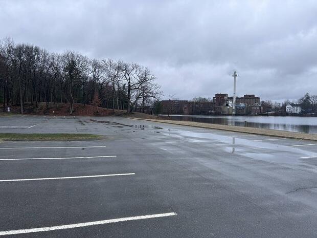 Large asphalt parking lot associated with learned pond beach