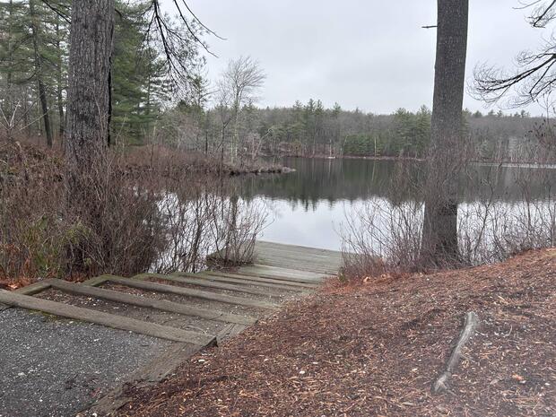 dirt path leading to steps that lead out onto a wooden dock over the water