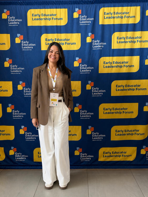 a woman standing in front of a background that says "Early Educator Leadership Forum"