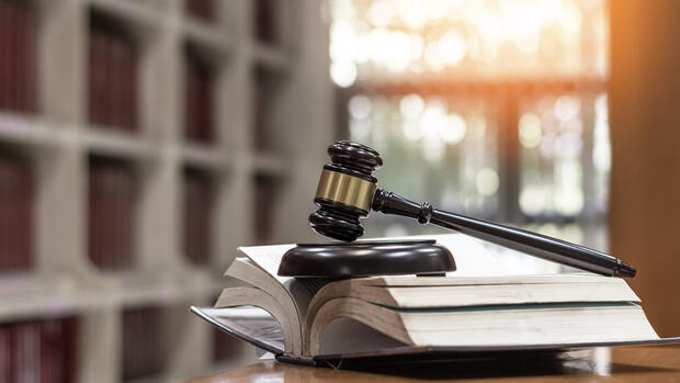 Gavel laying on top of an open law book