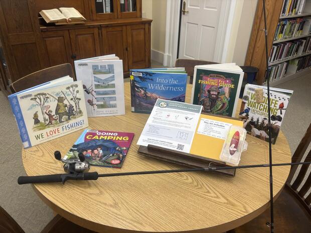 Display of books and fishing rods on a table