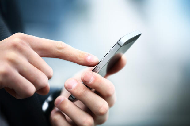 hands dialing on a phone to reach a helpline