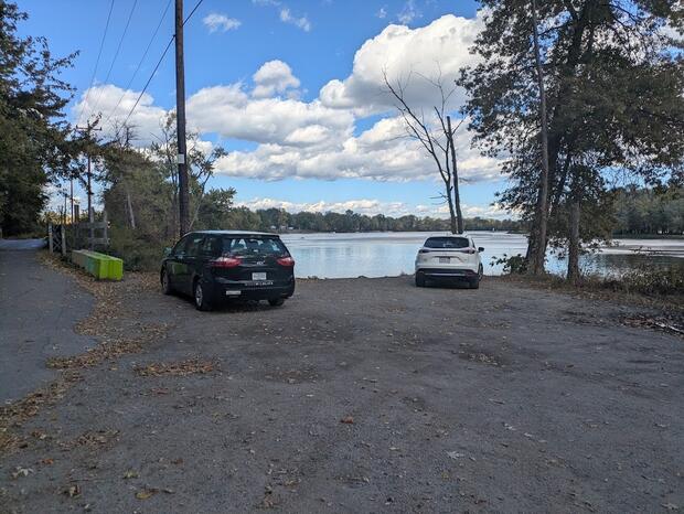 small gravel parking area by bridge overlooking water