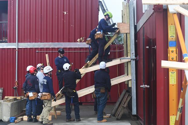 Firefighters using dimensional lumber to stabilize a building