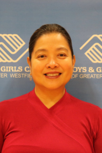 Smiling woman in a red top in front of a Boys & Girls Clubs backdrop.