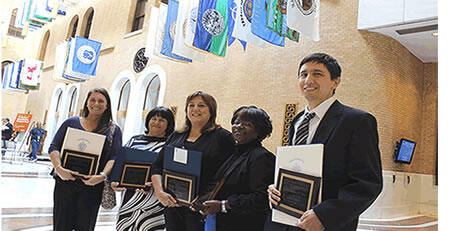 Group of people standing and holding awards