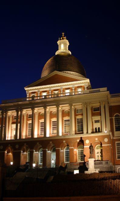 Image of the Massachusetts State House lit up night.
